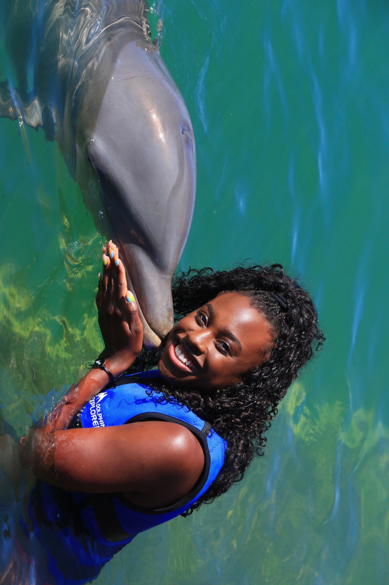 Amanda sharing a joyful moment with a dolphin in the water